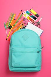 Photo of Backpack and different school supplies on pink background, flat lay