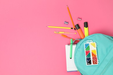 Photo of Backpack and different school supplies on pink background, flat lay. Space for text