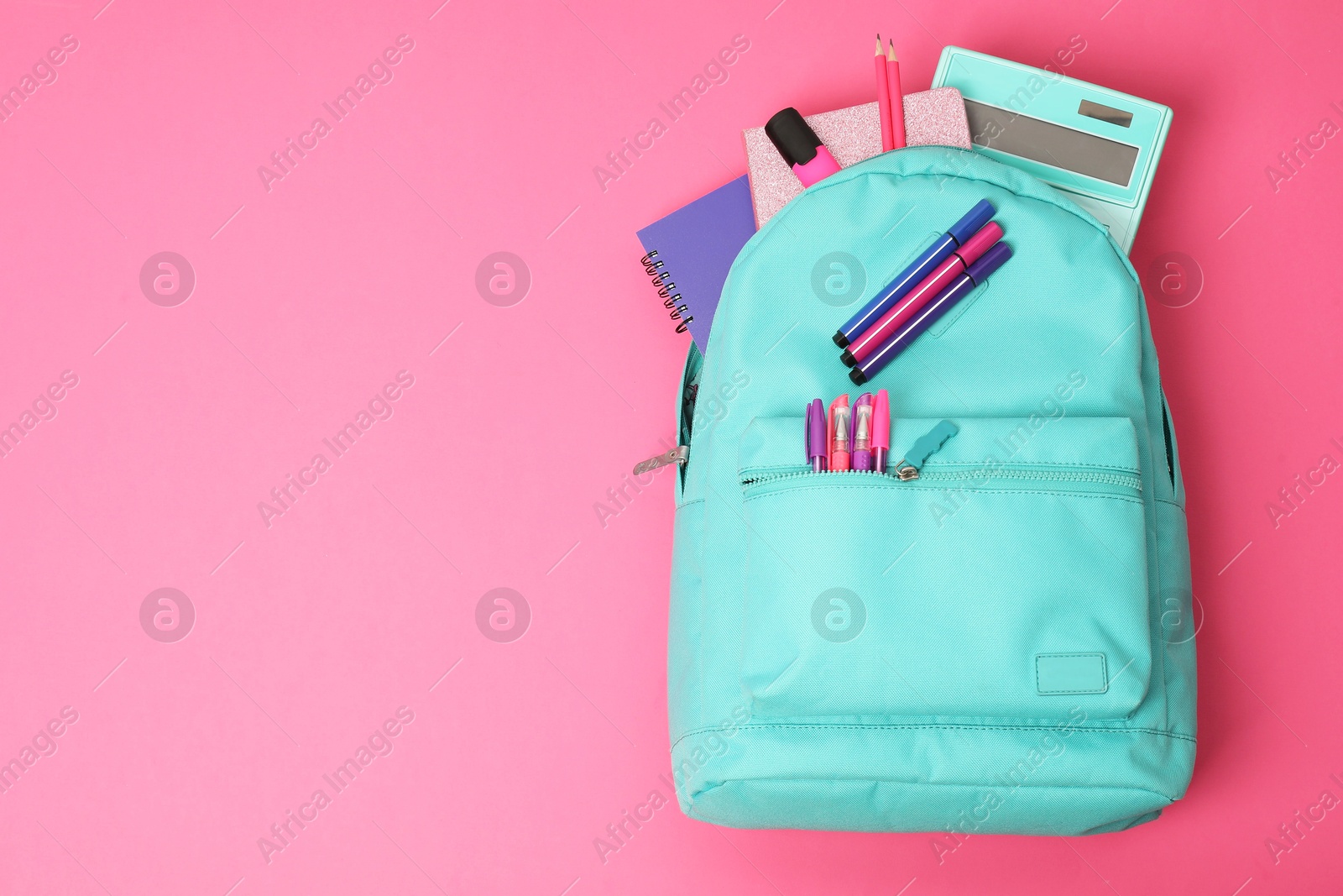 Photo of Backpack and different school supplies on pink background, top view. Space for text