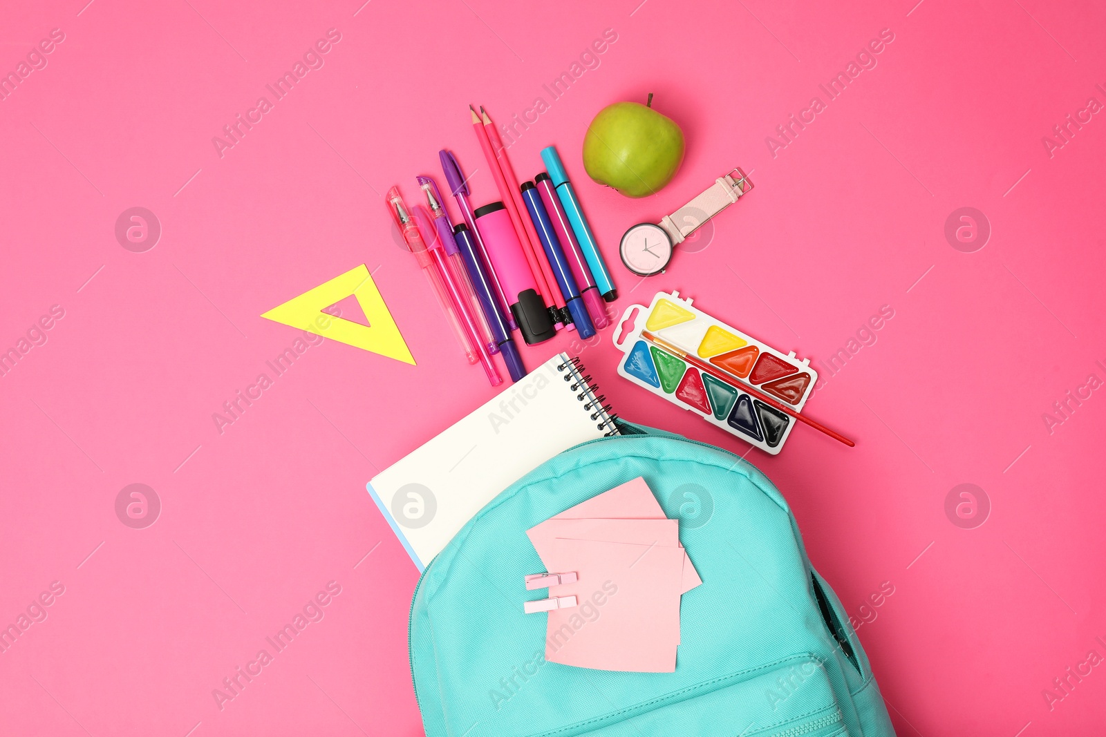 Photo of Backpack and different school supplies on pink background, flat lay