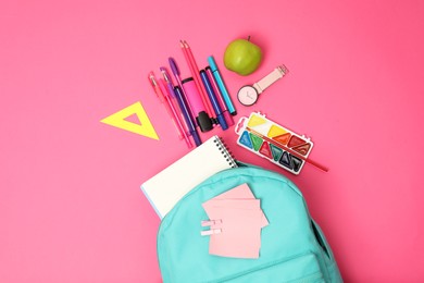 Backpack and different school supplies on pink background, flat lay