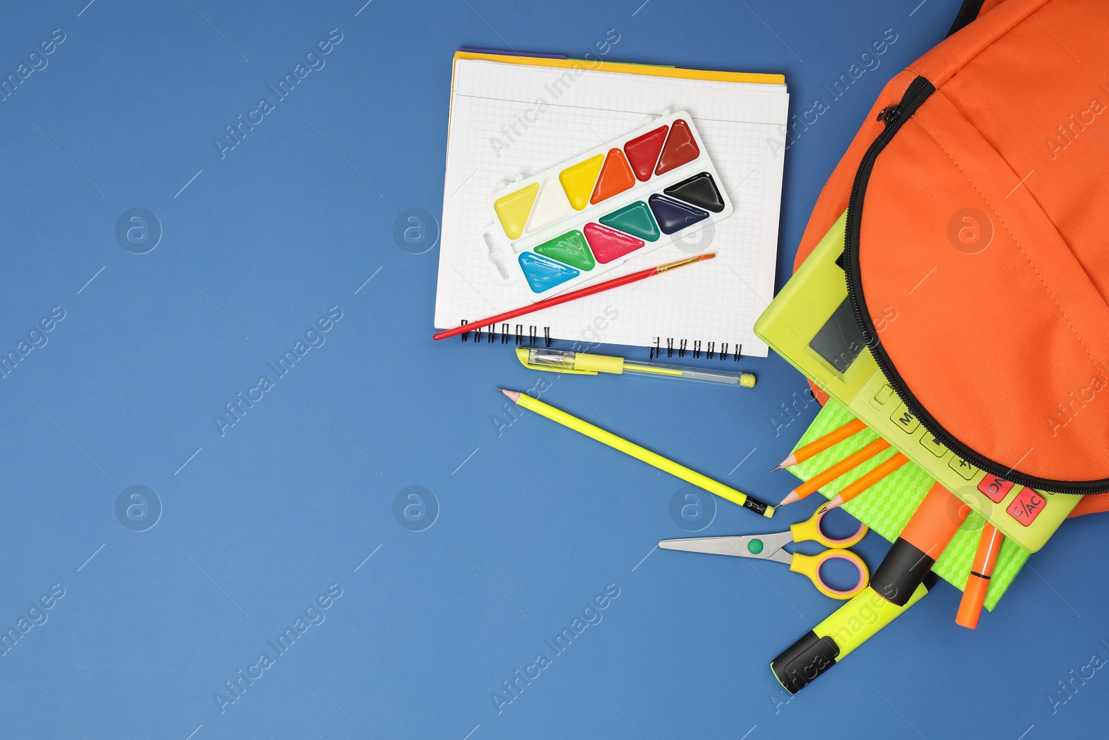 Photo of Backpack and different school supplies on blue background, flat lay. Space for text