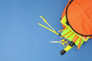 Photo of Backpack and different school supplies on blue background, flat lay. Space for text