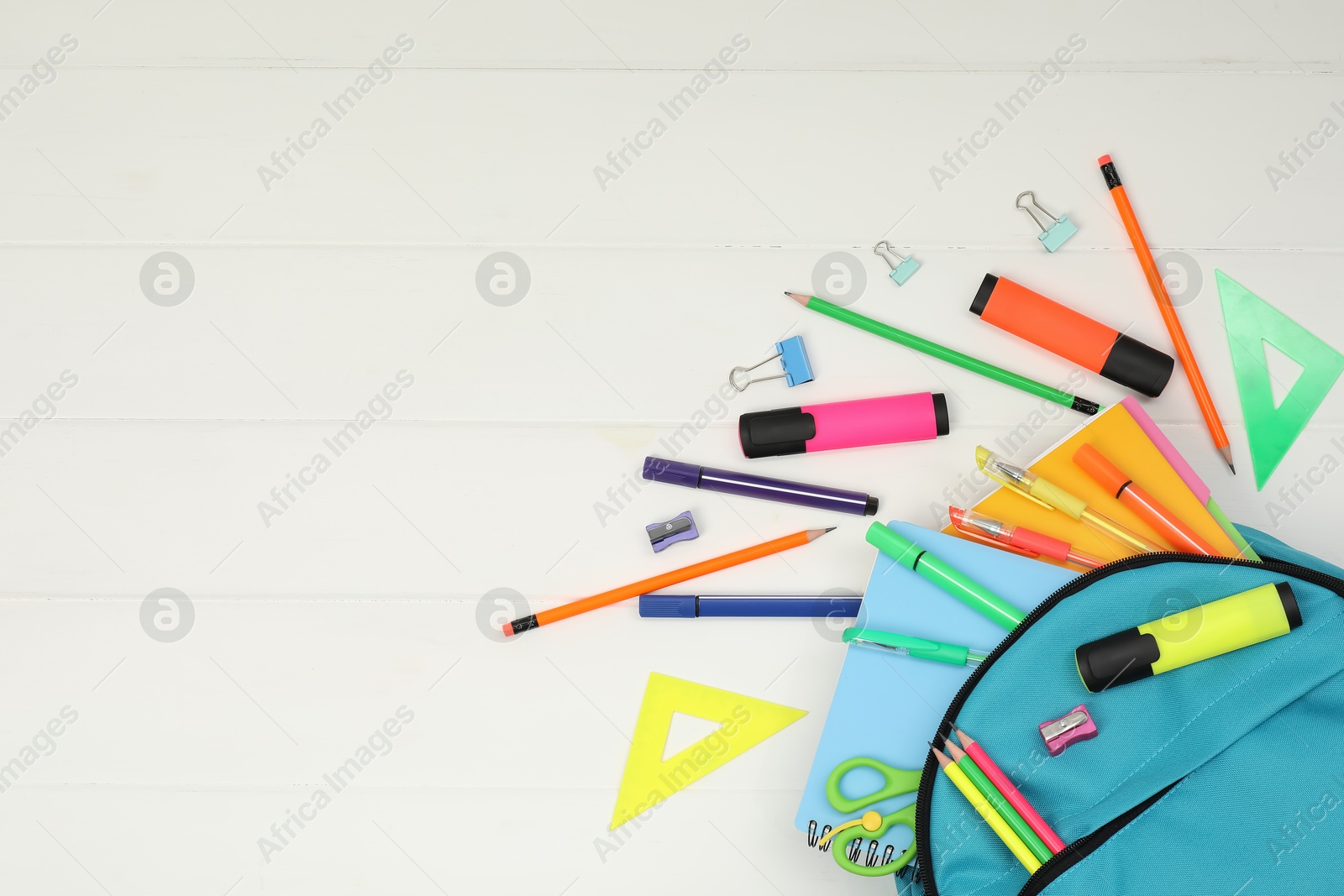 Photo of Backpack and different school supplies on white wooden background, flat lay. Space for text