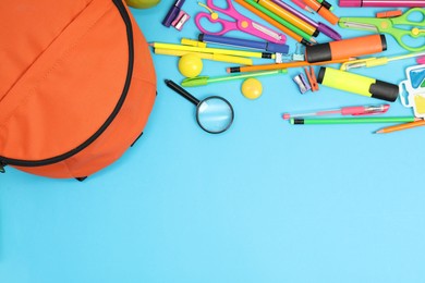 Photo of Backpack and different school supplies on light blue background, flat lay. Space for text