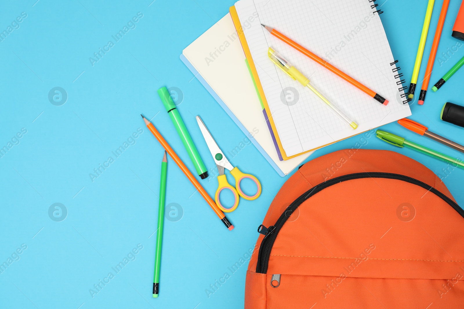 Photo of Backpack and different school supplies on light blue background, flat lay. Space for text