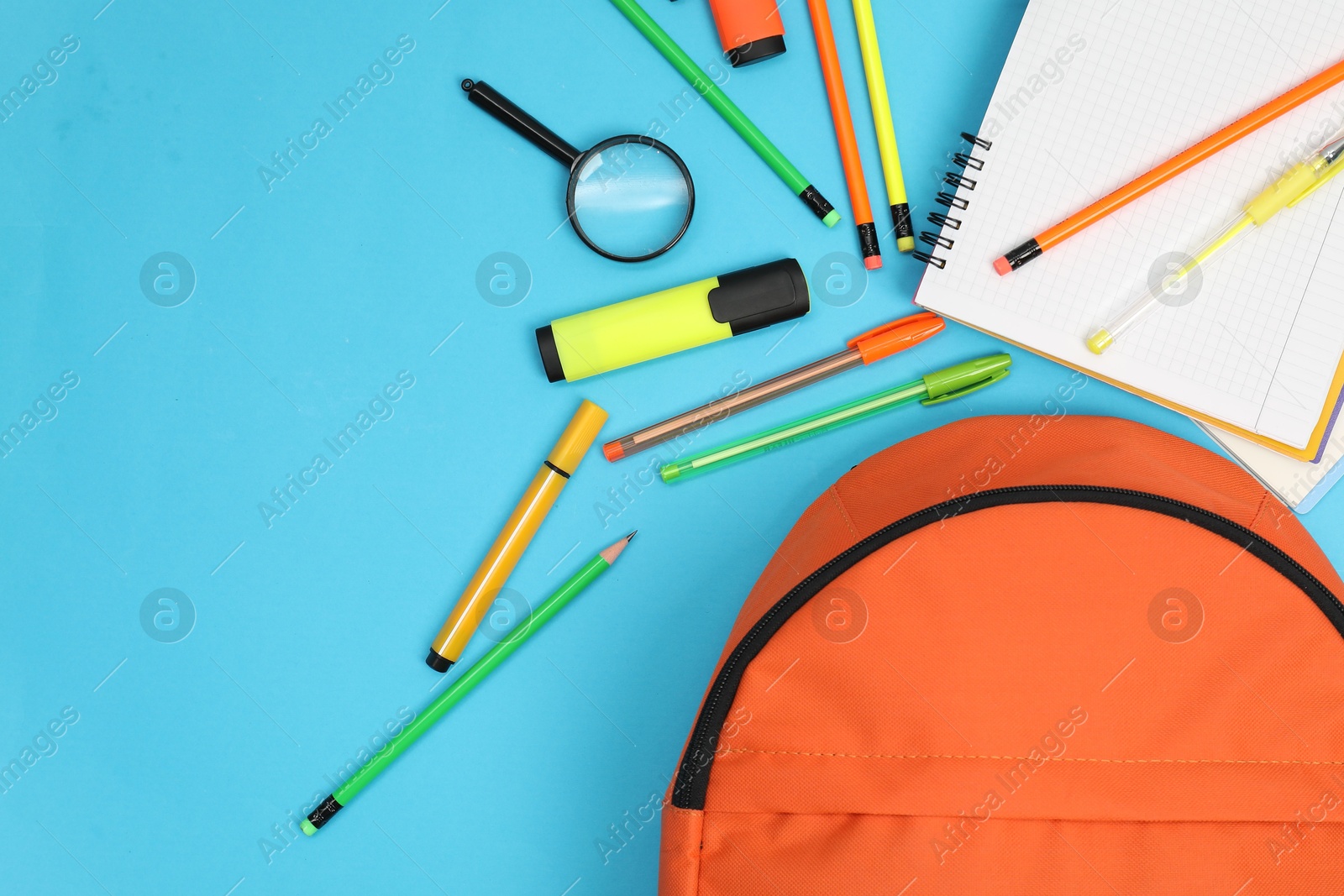 Photo of Backpack and different school supplies on light blue background, flat lay. Space for text