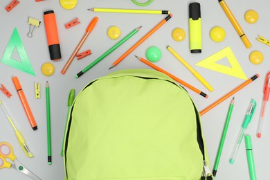 Photo of Backpack and different school supplies on light gray background, flat lay