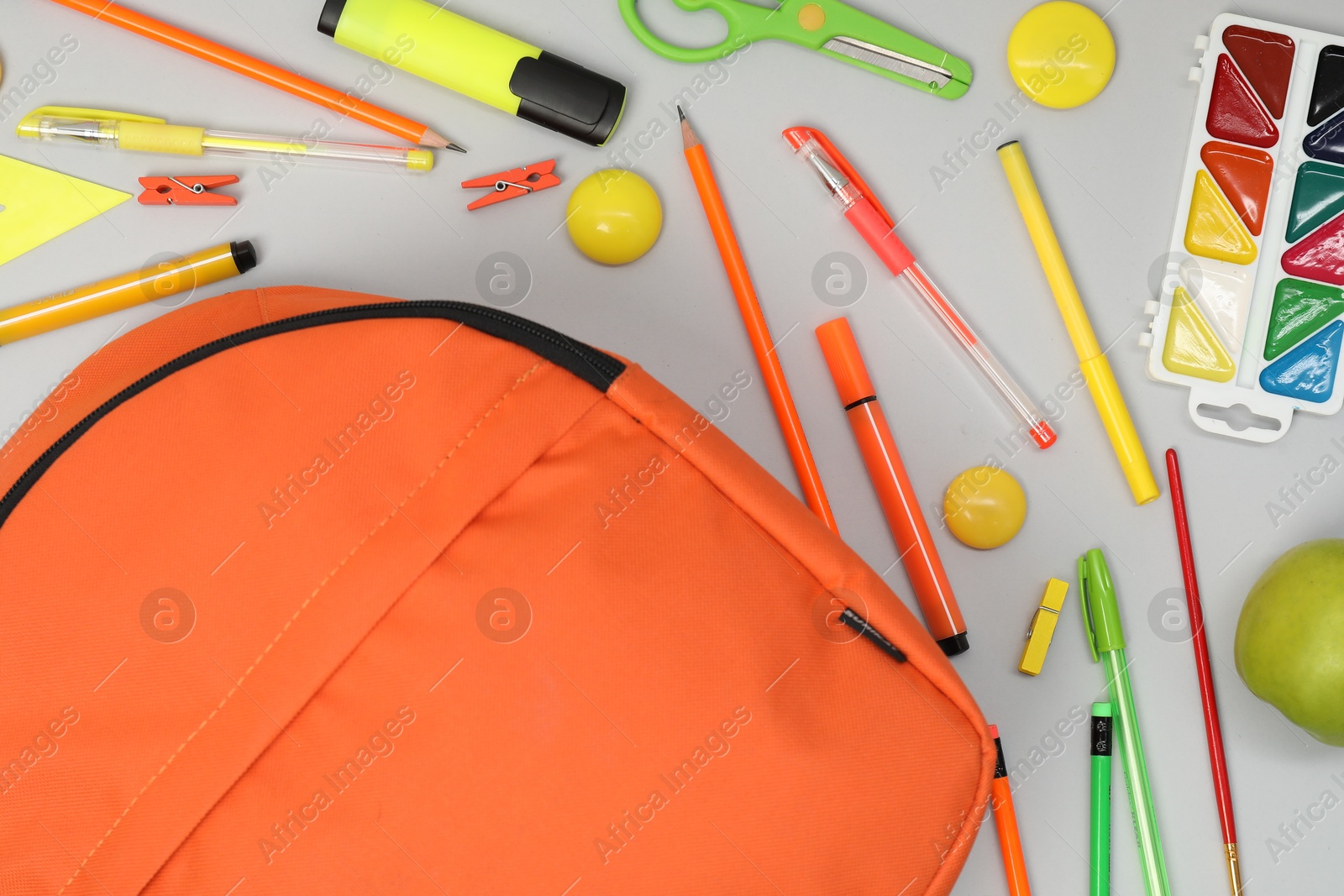 Photo of Backpack and different school supplies on light gray background, flat lay