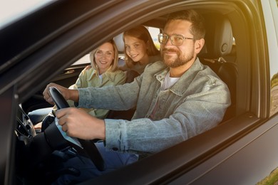 Happy family enjoying trip together by car on sunny day, view from outside