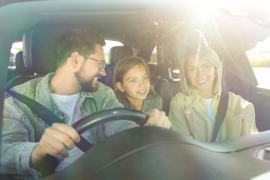 Image of Happy family enjoying trip together by car on sunny day, view through windshield