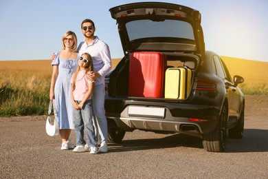 Image of Happy family enjoying road trip. Parents and daughter near car