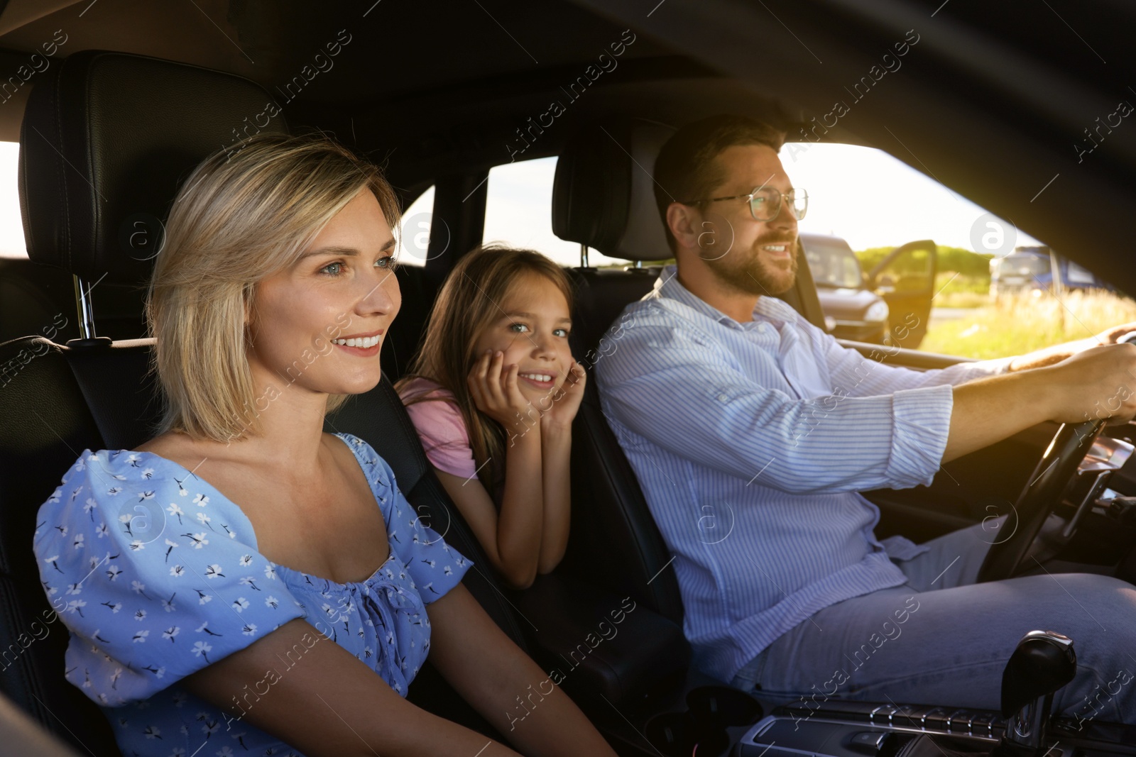 Image of Happy family on road trip. Parents with daughter in car