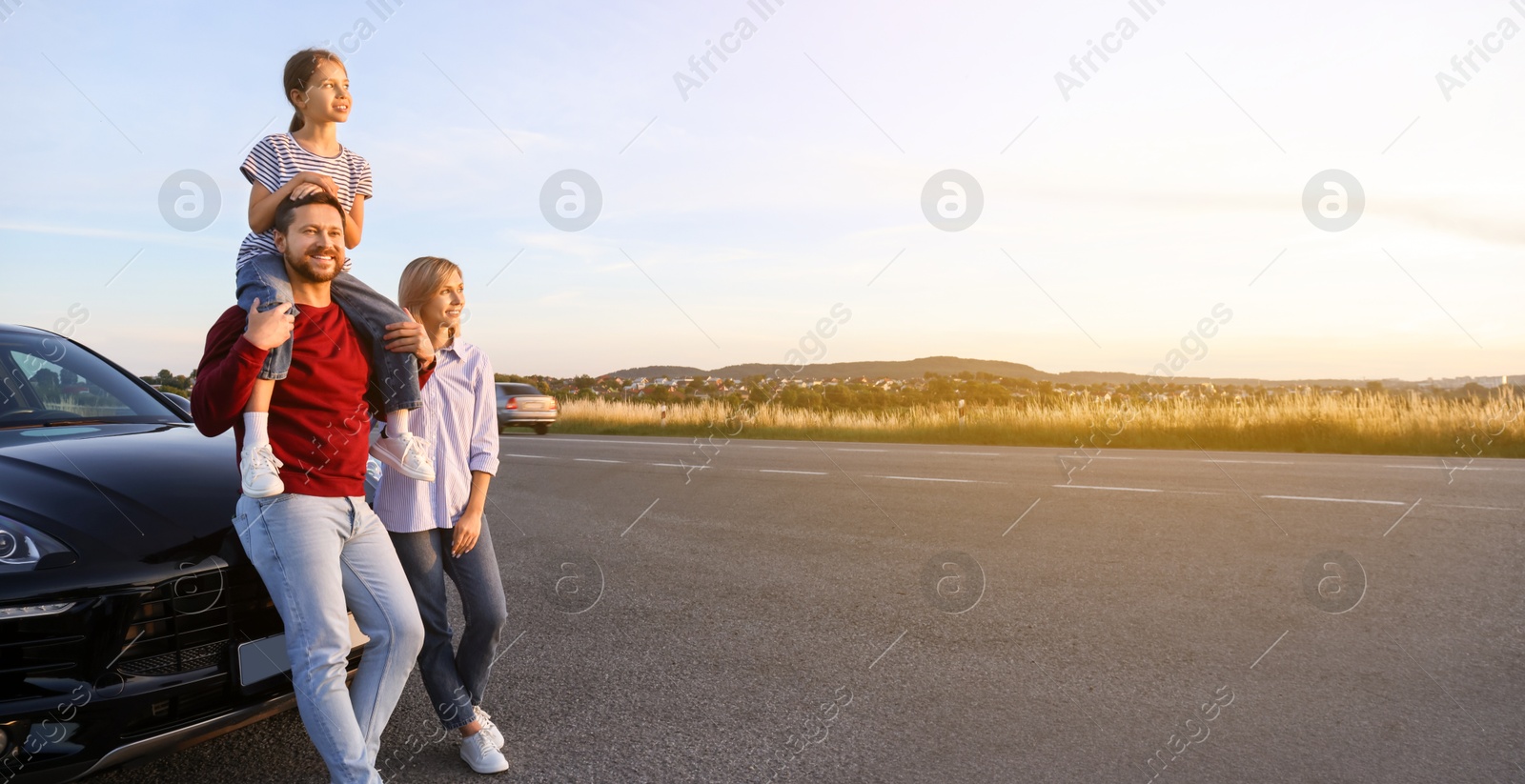 Image of Happy family near car on road trip. Banner design with space for text