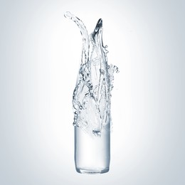 Image of Splashing water continuing shape of bottle on light background