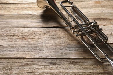 One trumpet on wooden table, closeup. Space for text