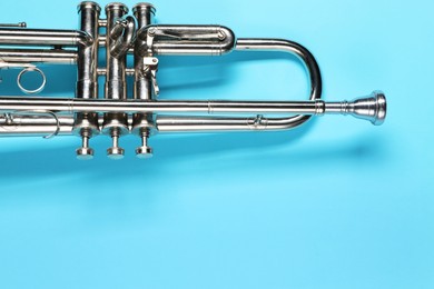 Photo of One trumpet on light blue background, top view. Space for text