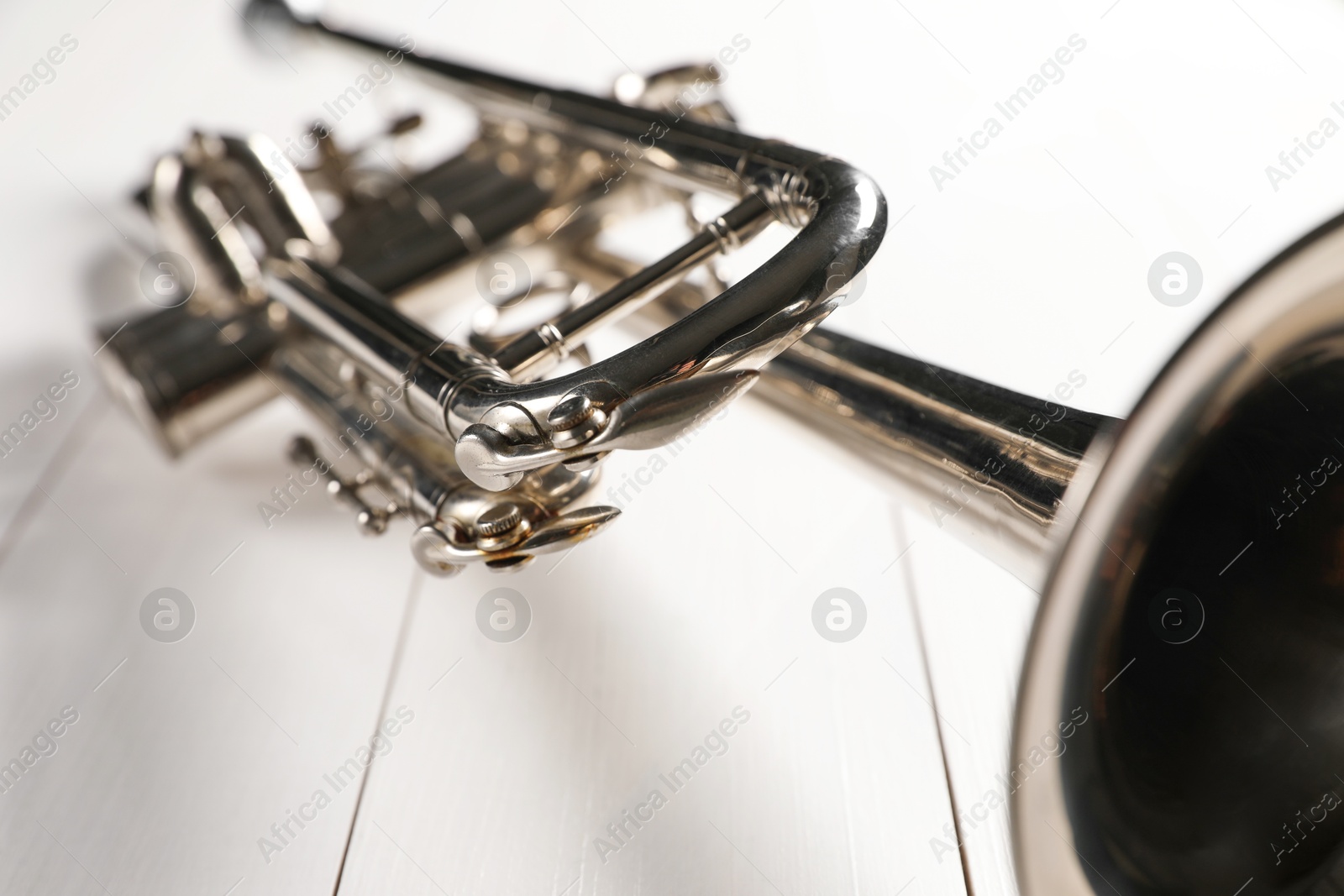 Photo of One trumpet on white wooden table, closeup