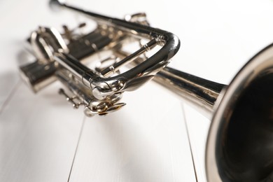 Photo of One trumpet on white wooden table, closeup