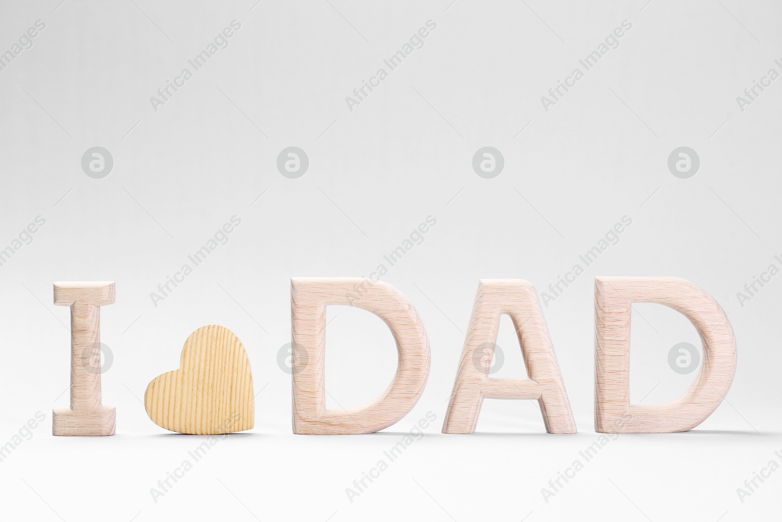 Photo of Happy Father's Day. Phrase I love Dad made with wooden letters and heart on light background