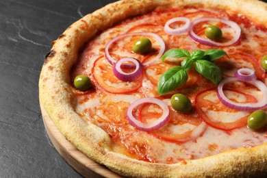 Photo of Delicious vegetarian pizza on black table, closeup