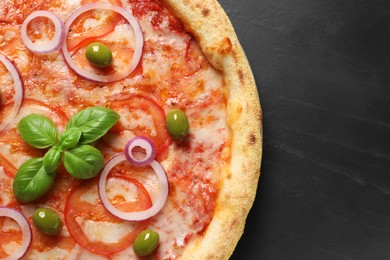 Photo of Delicious vegetarian pizza on black table, top view