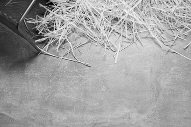 Photo of Shredded paper strips with trash bin on grey textured table, top view. Space for text