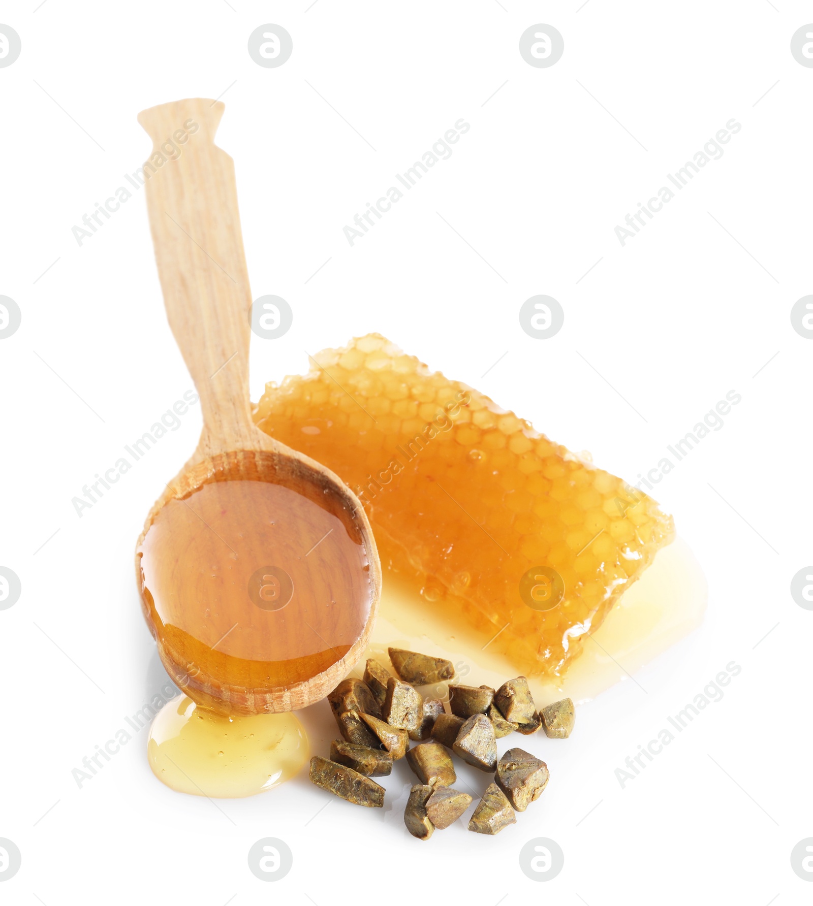 Photo of Sweet honeycomb, spoon and propolis granules isolated on white