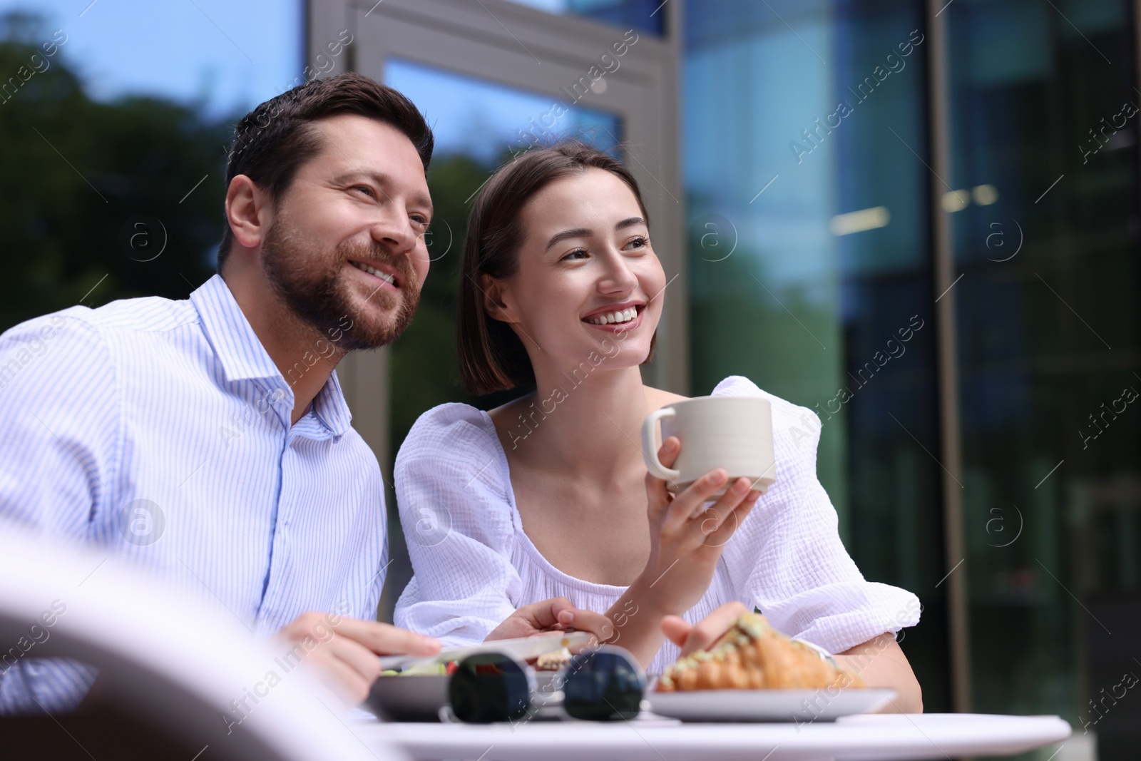 Photo of Happy couple having breakfast in outdoor cafe