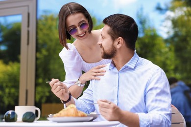 Happy couple having breakfast in outdoor cafe