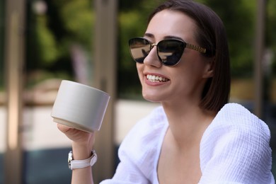 Photo of Happy woman having breakfast in outdoor cafe