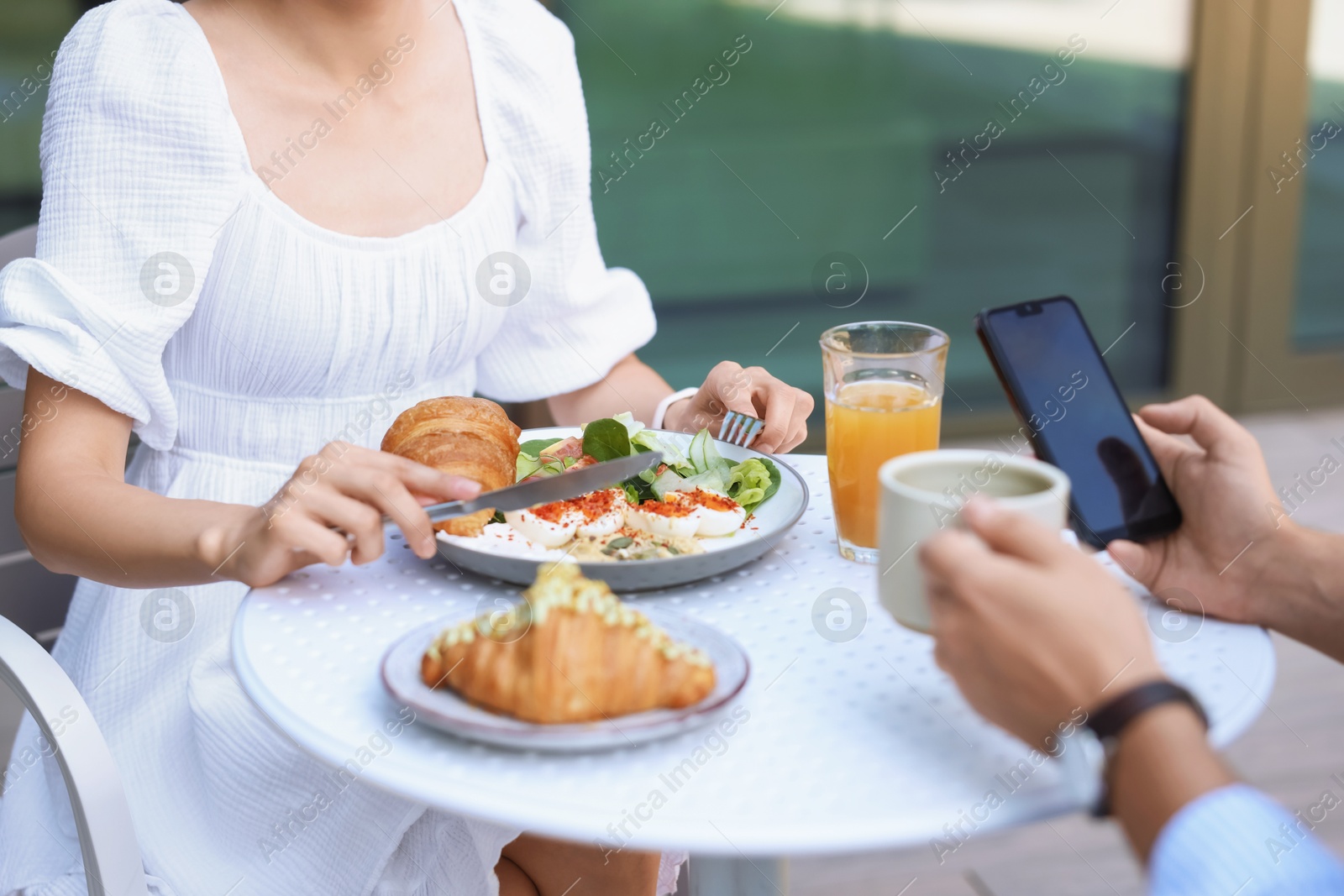 Photo of Couple having tasty breakfast in outdoor cafe, closeup