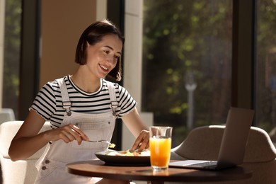 Photo of Happy woman having tasty breakfast in cafe