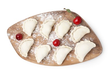 Raw dumplings (varenyky) and fresh cherries isolated on white, top view