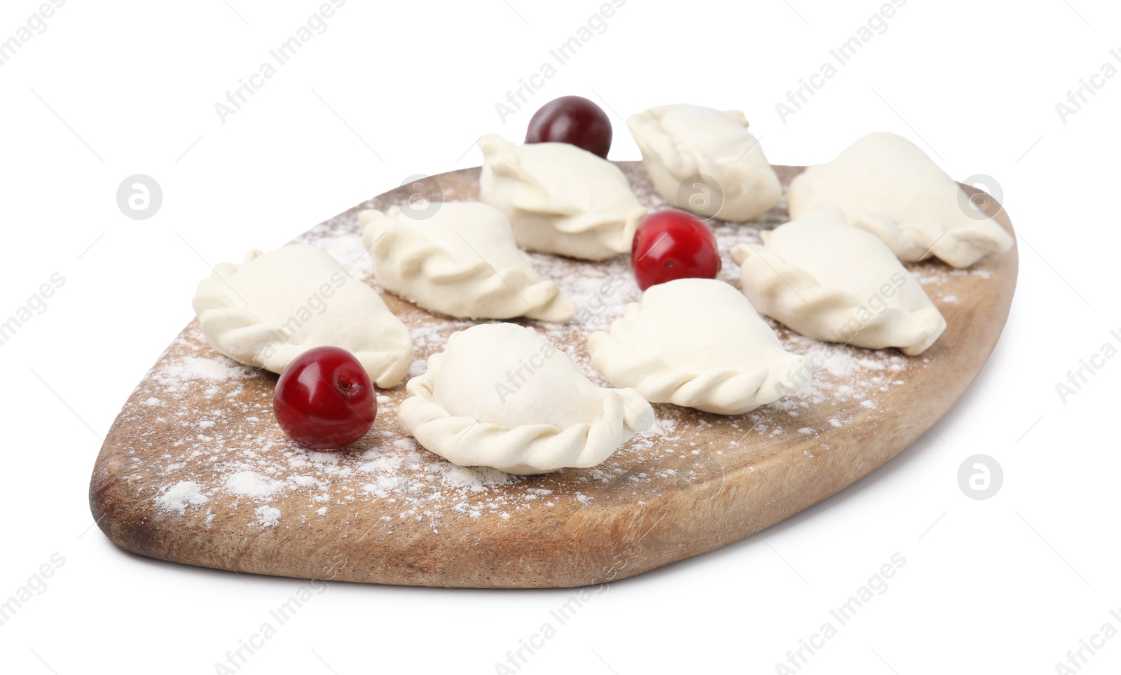 Photo of Raw dumplings (varenyky) and fresh cherries isolated on white