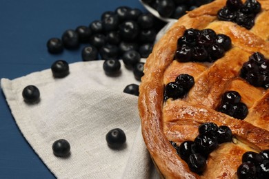 Tasty homemade pie with blueberries on blue table, closeup. Space for text