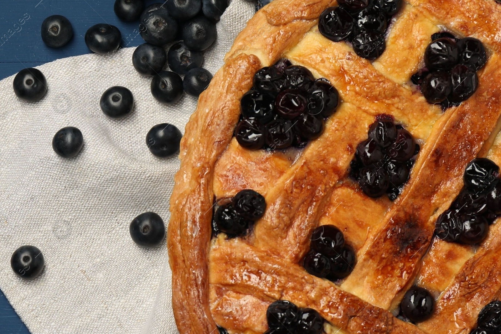 Photo of Tasty homemade pie with blueberries on blue table, flat lay