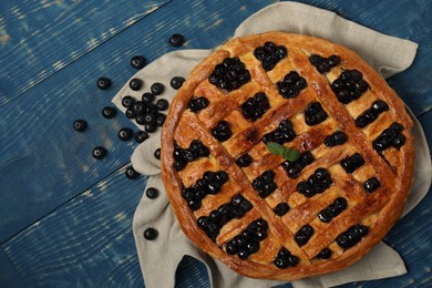 Photo of Tasty homemade pie with blueberries and mint on blue wooden table, flat lay