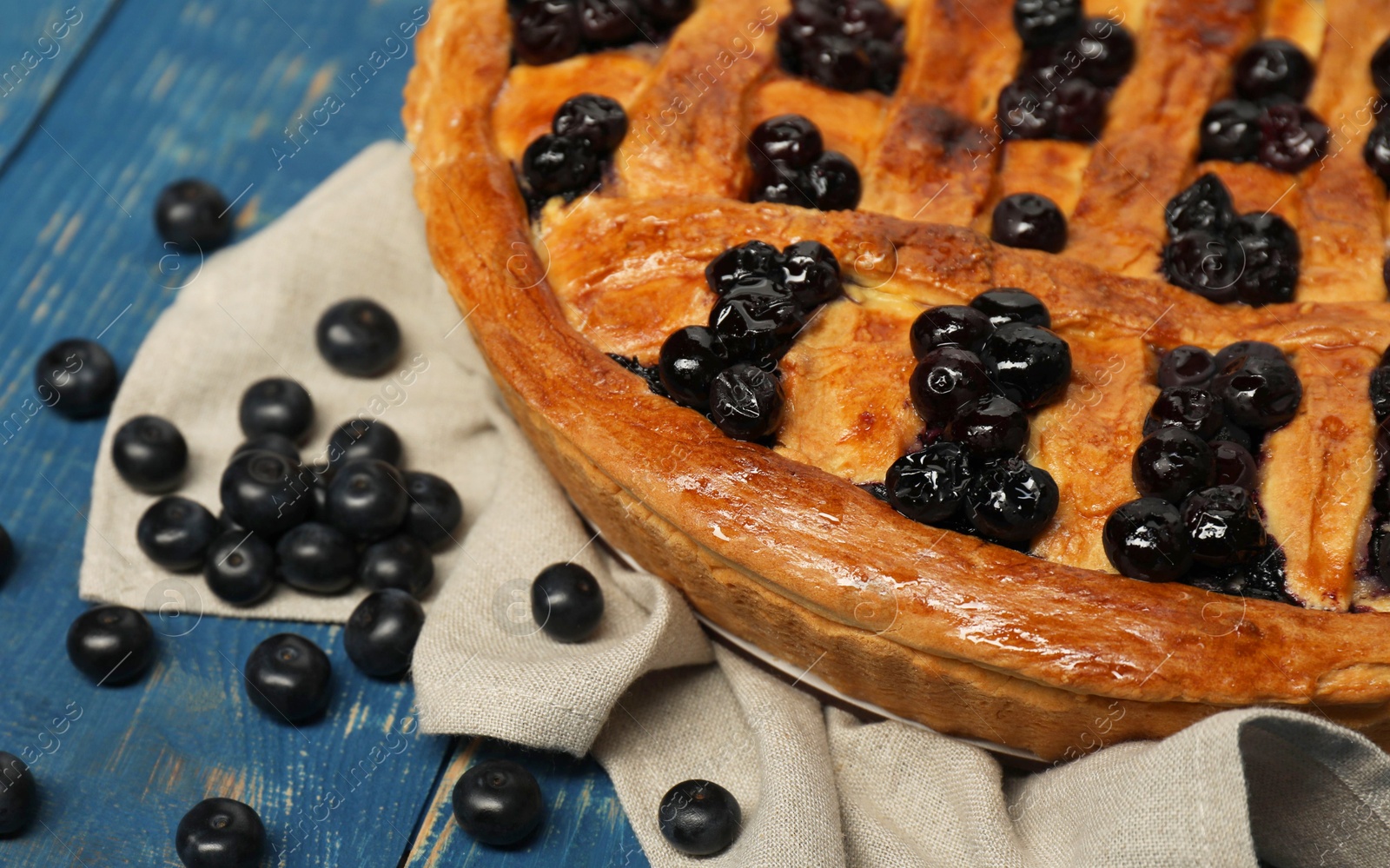 Photo of Tasty homemade pie with blueberries on blue wooden table, closeup