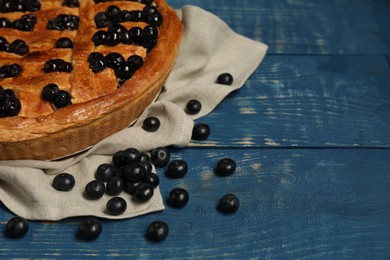 Photo of Tasty homemade pie with blueberries on blue wooden table, space for text