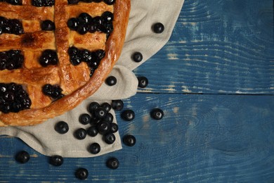 Photo of Tasty homemade pie with blueberries on blue wooden table, flat lay. Space for text