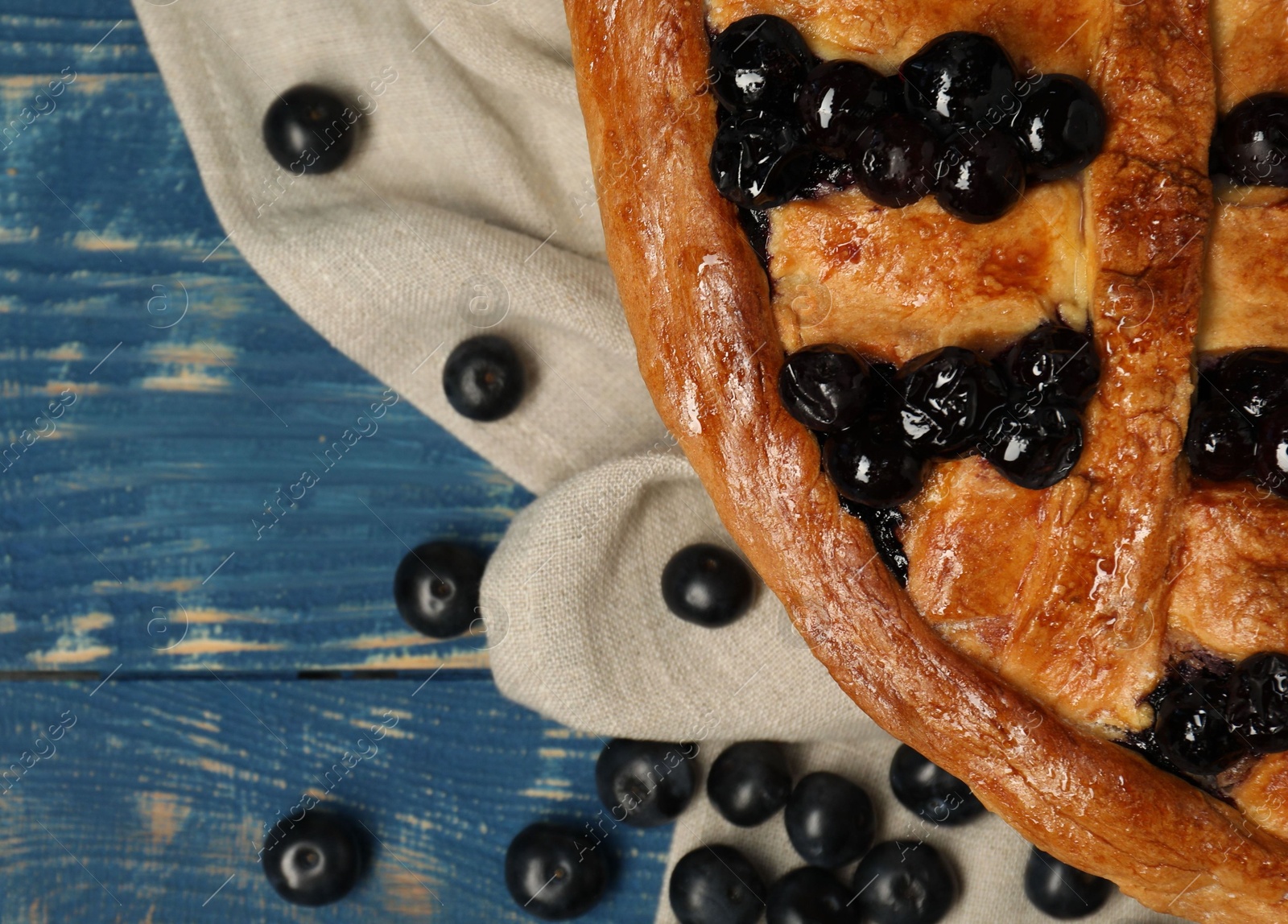 Photo of Tasty homemade pie with blueberries on blue wooden table, flat lay. Space for text