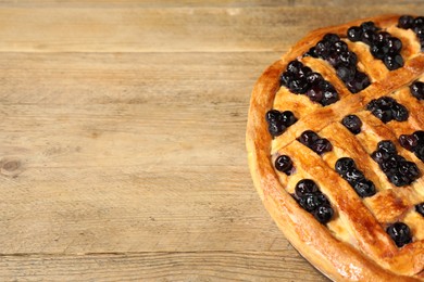 Photo of Tasty homemade pie with blueberries on wooden table, closeup. Space for text