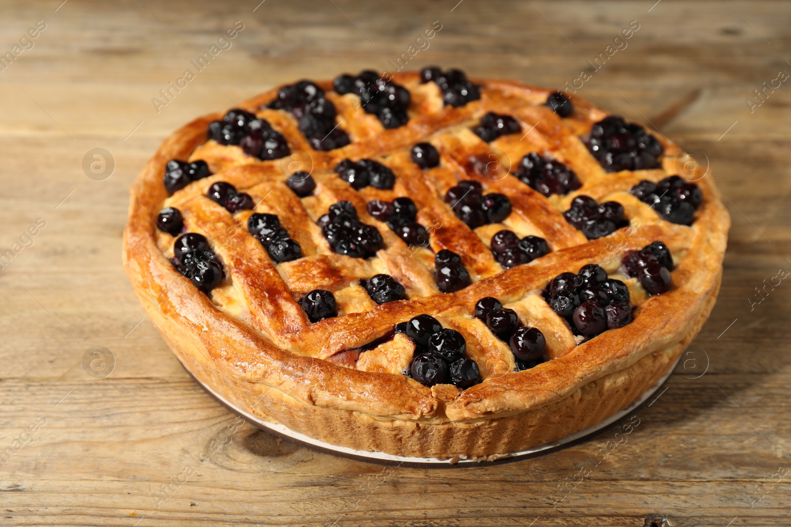 Photo of Tasty homemade pie with blueberries on wooden table, closeup