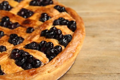 Photo of Tasty homemade pie with blueberries on wooden table, closeup. Space for text