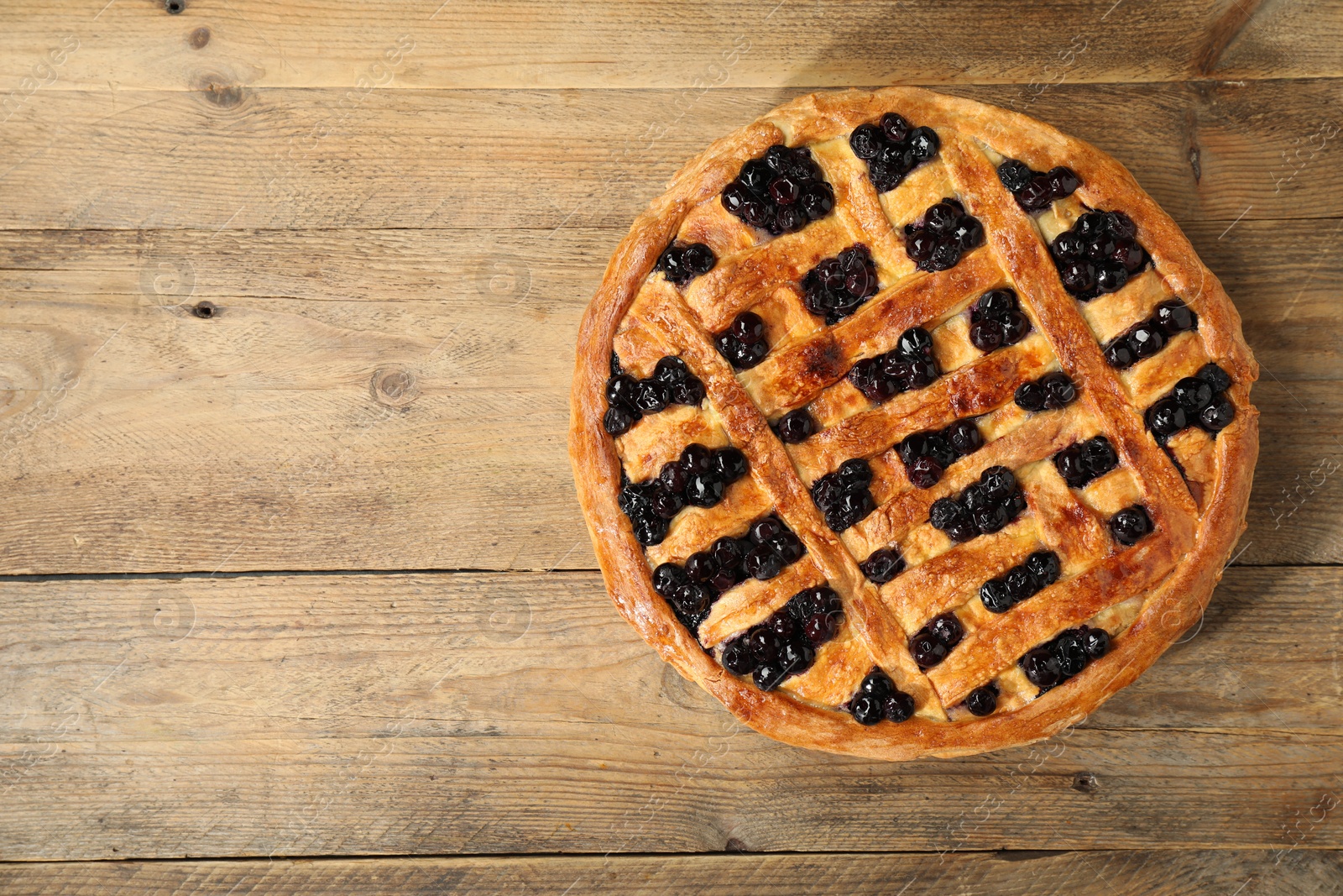 Photo of Tasty homemade pie with blueberries on wooden table, top view. Space for text