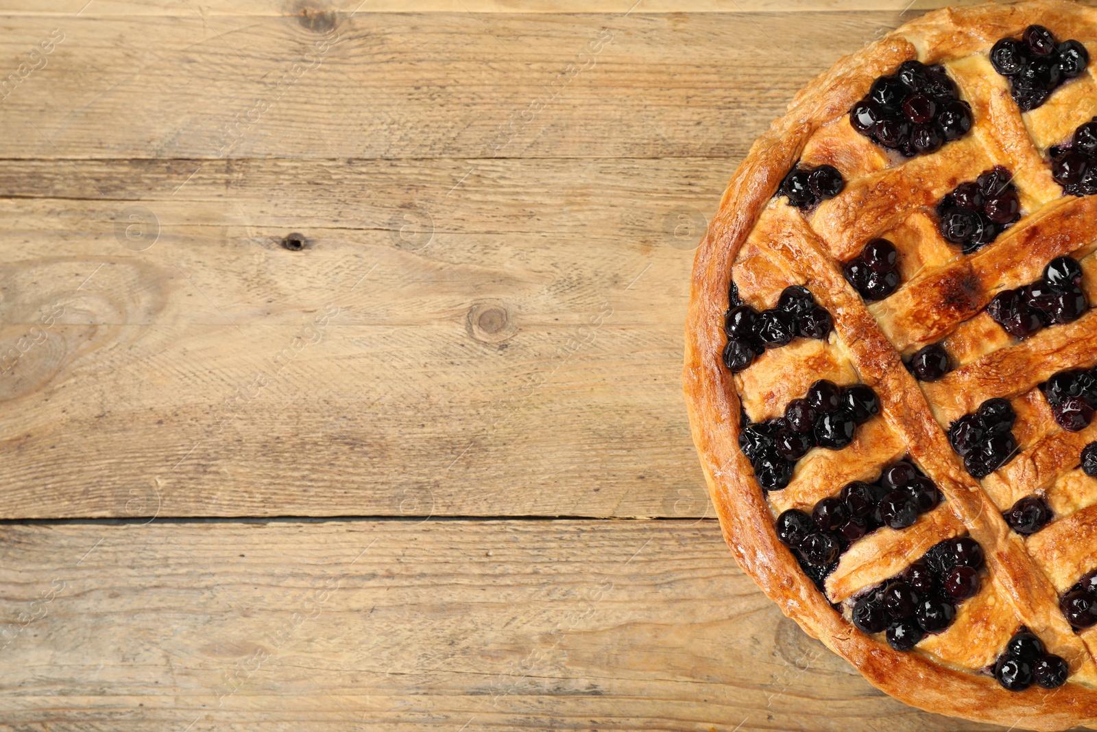 Photo of Tasty homemade pie with blueberries on wooden table, top view. Space for text