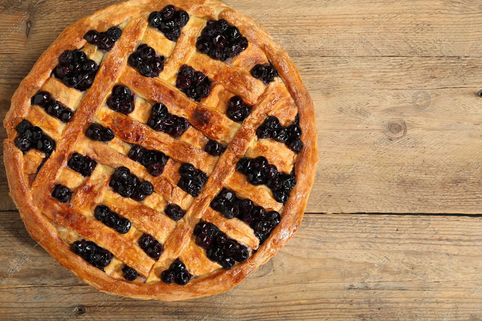 Photo of Tasty homemade pie with blueberries on wooden table, top view. Space for text