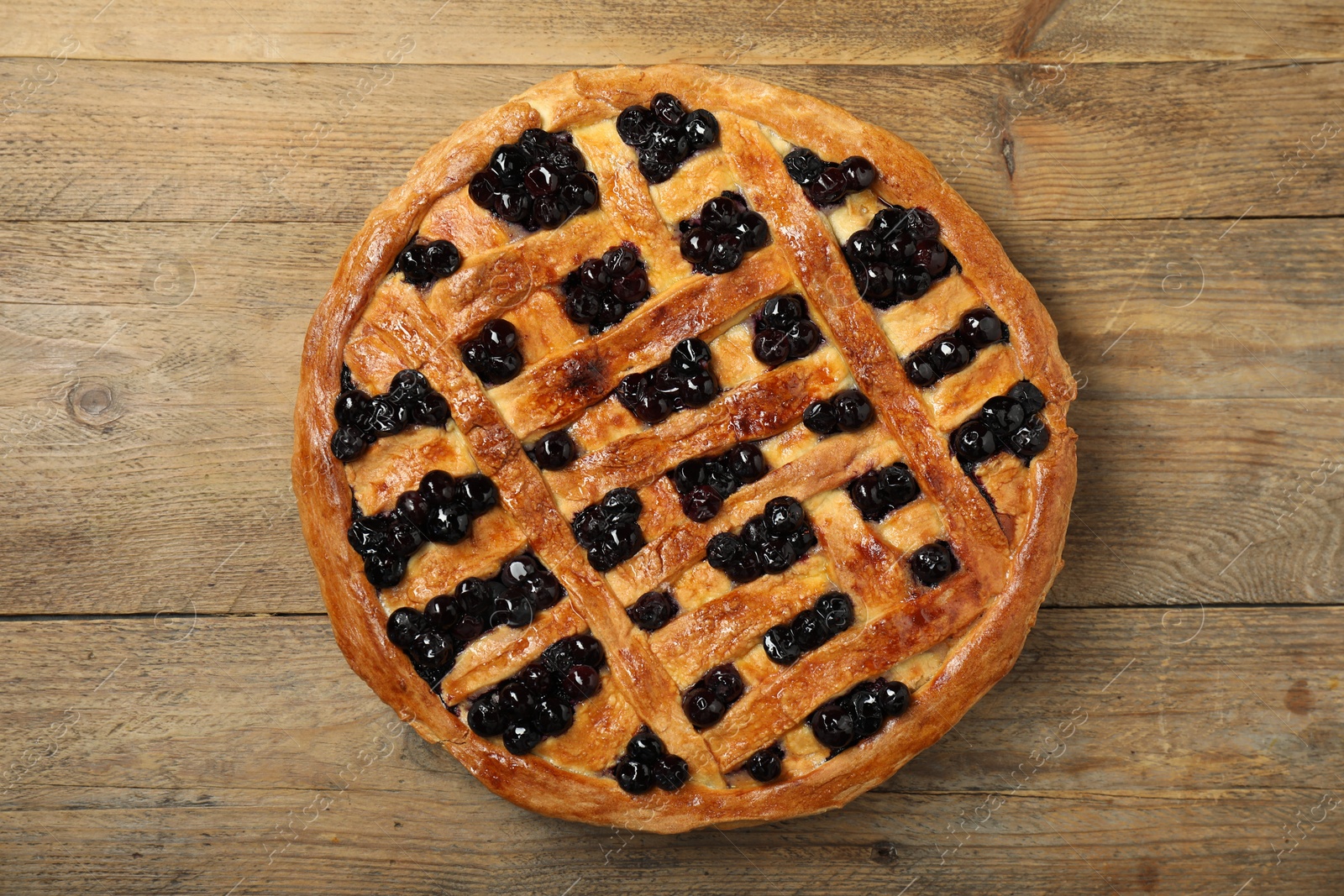 Photo of Tasty homemade pie with blueberries on wooden table, top view