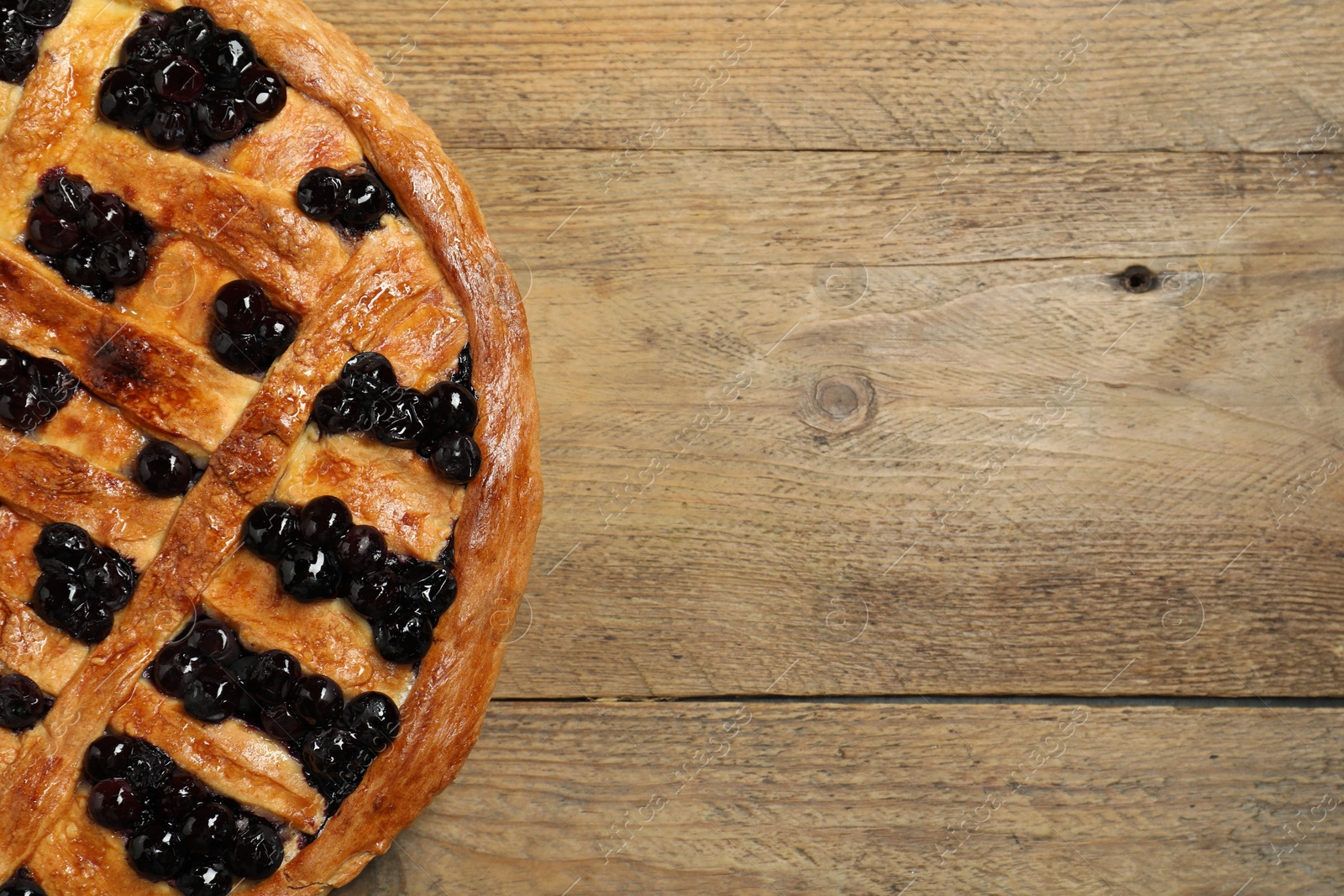 Photo of Tasty homemade pie with blueberries on wooden table, top view. Space for text